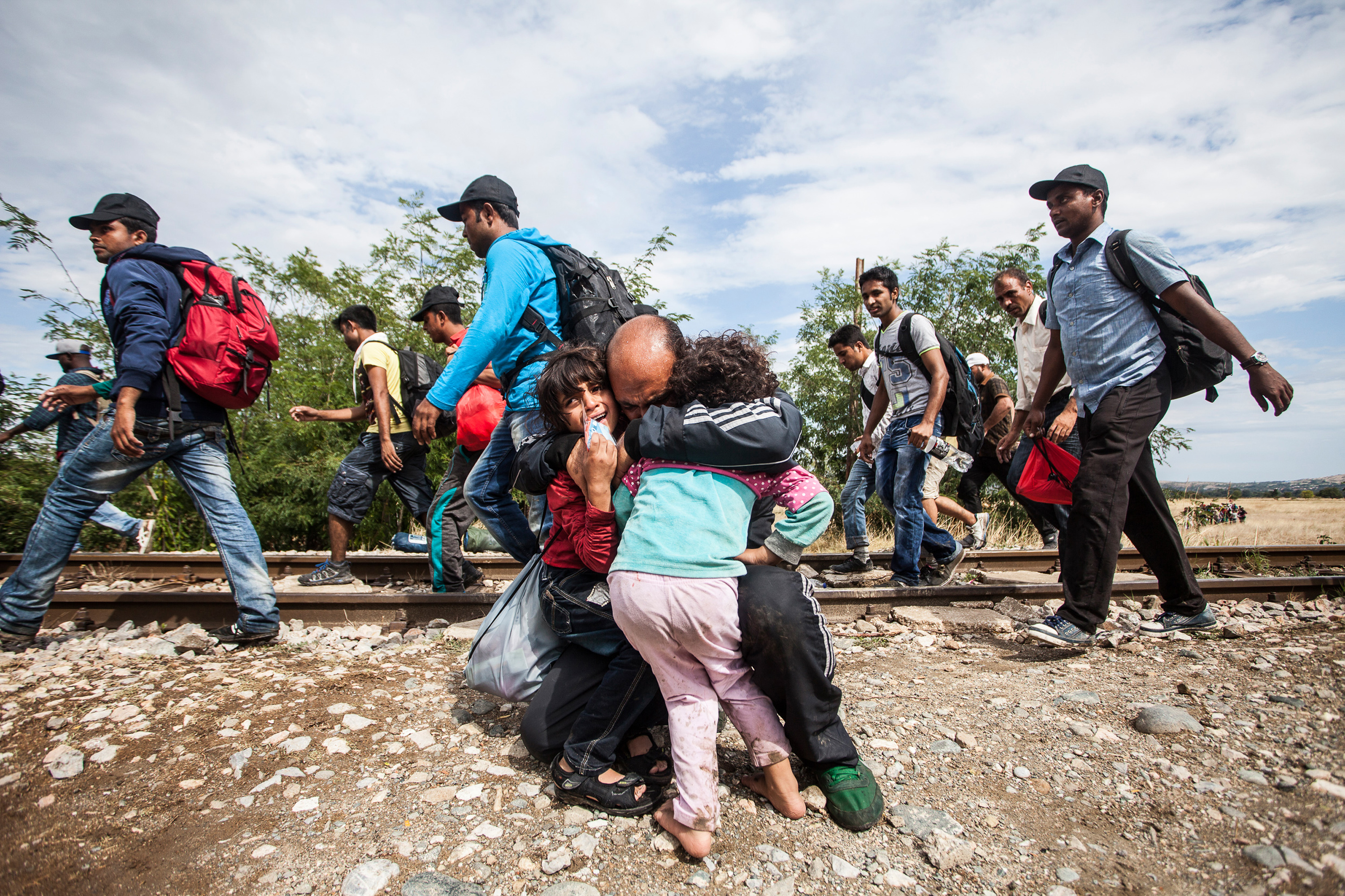 Father hugs his lost children after the clashes erupted at the border between Greece and Macedonia. Tens of thousands of migrants were stranded on no manâs land between border lines for days, exposed to high temperatures during the day, rain and cold over night, which caused tension and several attempts to breach the Macedonian police lines. Photo by Igor Pavicevic / Kamerades