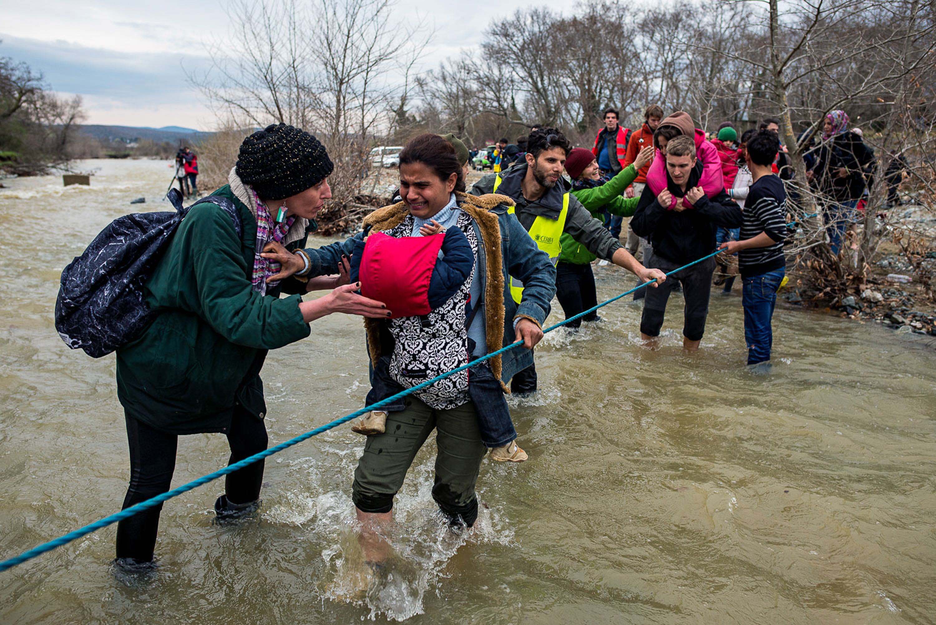 Volunteers help refugees to cross the river. As border is closed, refugees cross the river trying to find alternative way to enter Macedonia. Greece, 14.03.2016.