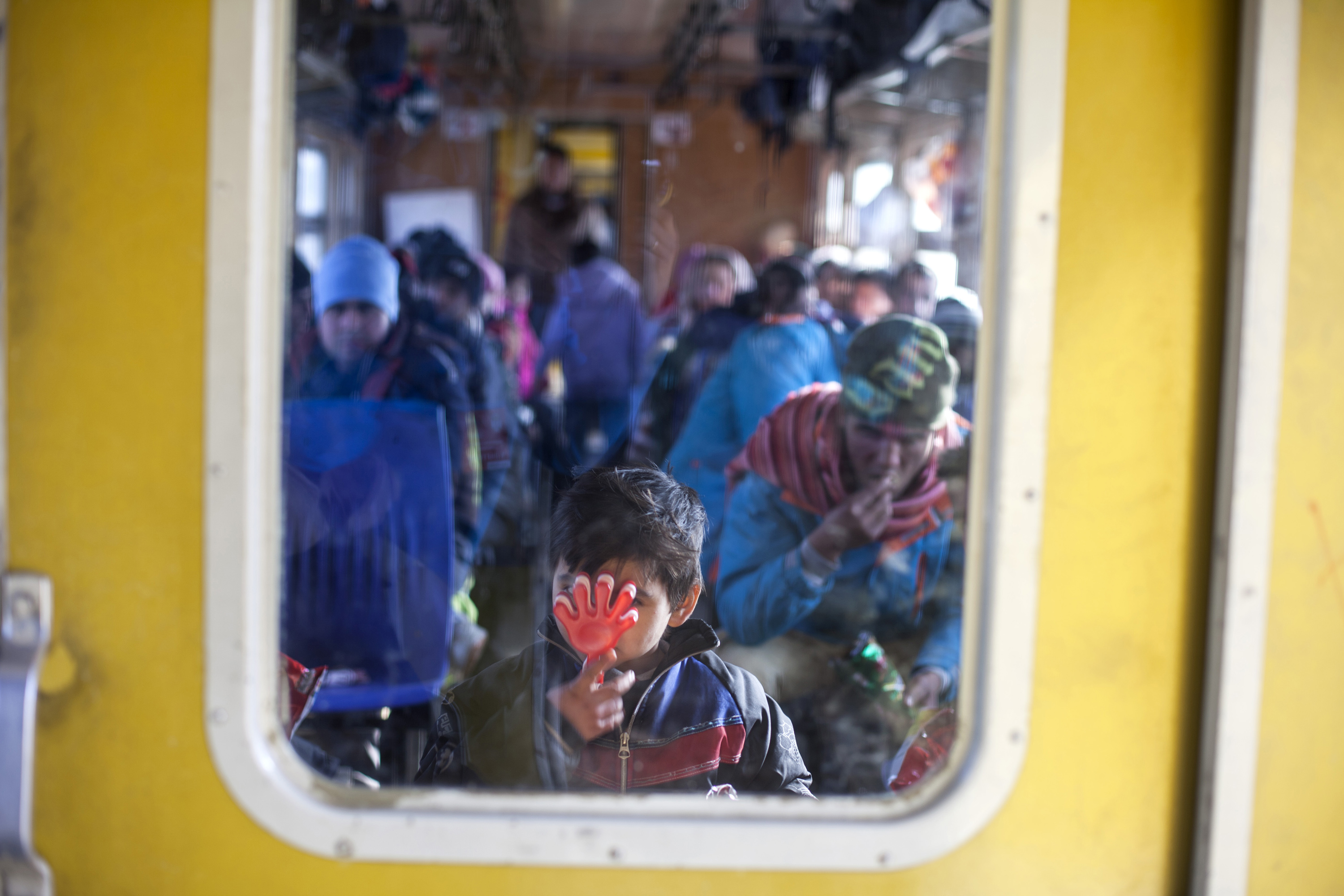A boy playing with a hand toy together with his family aboard a train heading towards Belgrade taking refugees to a next point on their long journey away from home. 23.01.2016 Presevo, Serbia