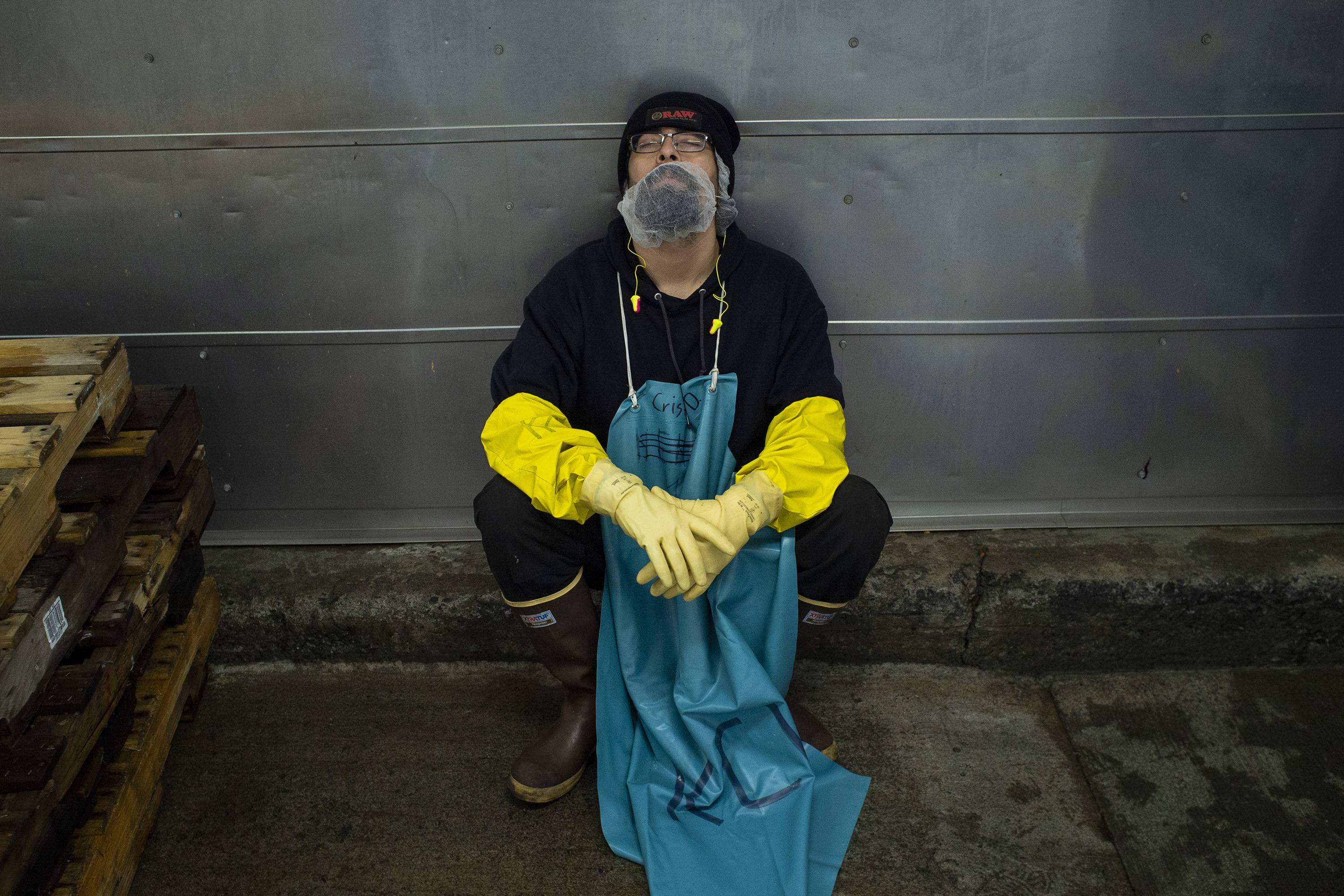 Worker in his working chlotes sleep inside of the fish factory in Kodiak during unexpected break due machine failure